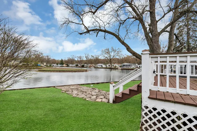 a view of a house with a yard and a large tree