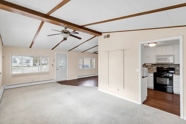 a view of a livingroom with an empty space and a window