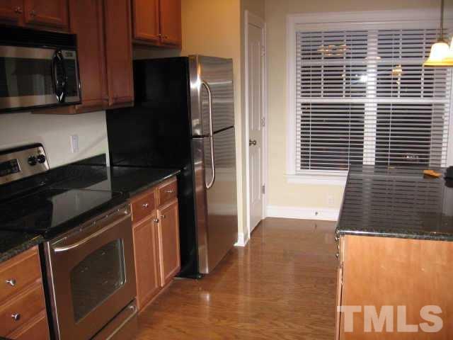 7761 Courtney Estates Drive Raleigh, NC 27617 - Photo 5 of 6 a kitchen with a refrigerator an oven