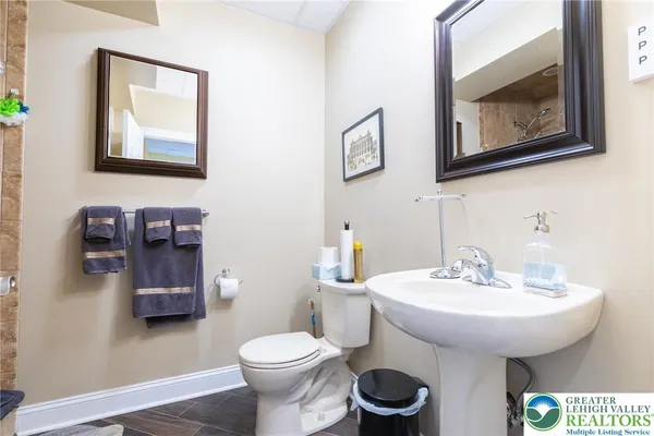 a bathroom with a toilet a sink and mirror