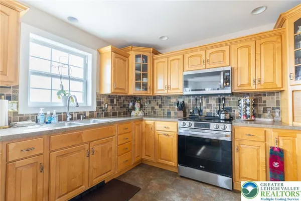a kitchen with stainless steel appliances granite countertop a stove a sink and a microwave