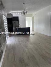 5610 Northwest 187th Street, Unit 5610 Miami Gardens, FL 33055 - Photo 3 of 7 a view of a room with gym equipment and a chandelier