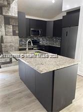 5610 Northwest 187th Street, Unit 5610 Miami Gardens, FL 33055 - Photo 4 of 7 a kitchen with stainless steel appliances a sink stove and refrigerator