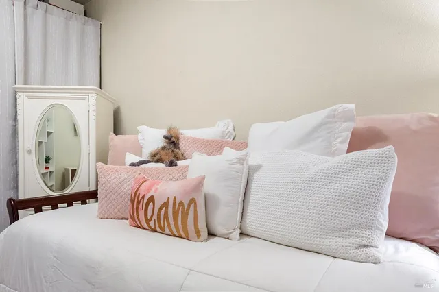 a bedroom with a bed and painting on the wall