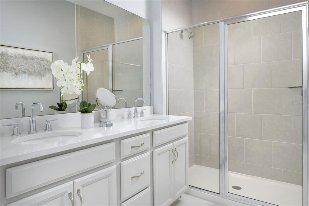 1859 Seawall Way Celebration, FL 34747 - Photo 11 of 25 a bathroom with a granite countertop sink a mirror and shower