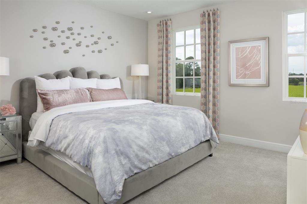 1859 Seawall Way Celebration, FL 34747 - Photo 10 of 25 a large bed sitting in a bedroom next to a window