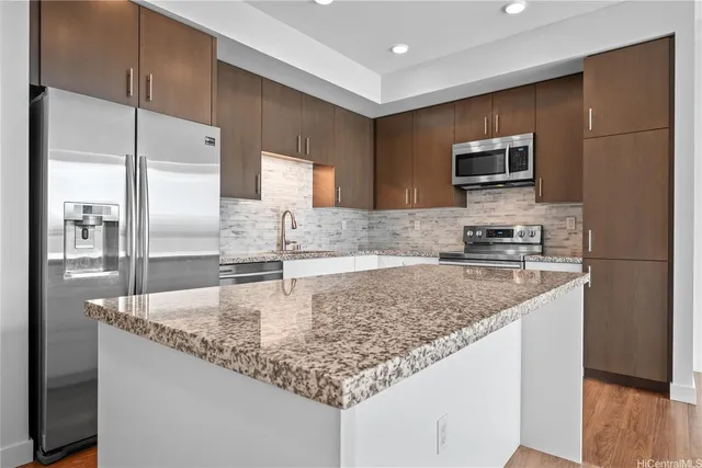 a kitchen with stainless steel appliances granite countertop a sink refrigerator and microwave