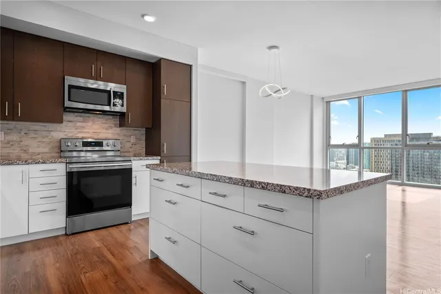 a kitchen with stainless steel appliances granite countertop a stove a sink and a microwave