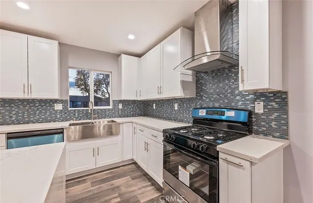 a kitchen with granite countertop white cabinets stainless steel appliances and a counter space