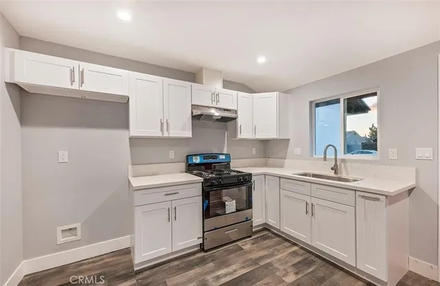a kitchen with a sink a stove and cabinets