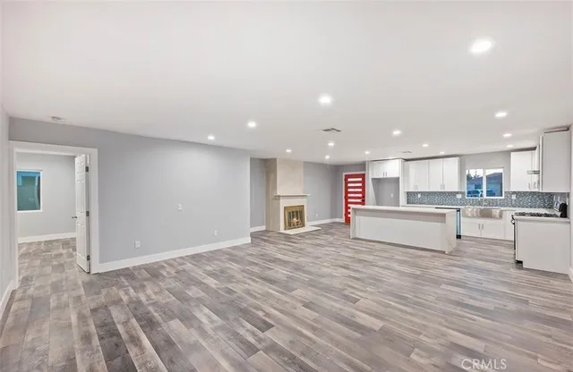 a large white kitchen with kitchen island a sink stainless steel appliances and white cabinets