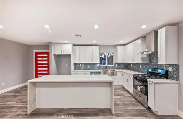 a kitchen with stainless steel appliances kitchen island granite countertop a stove a sink and a microwave