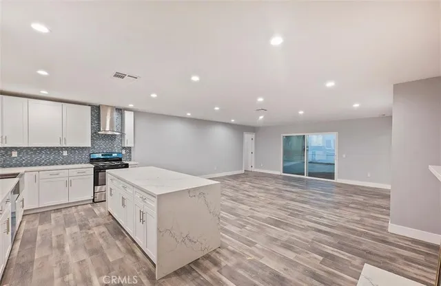 a large kitchen with kitchen island a sink stainless steel appliances and cabinets