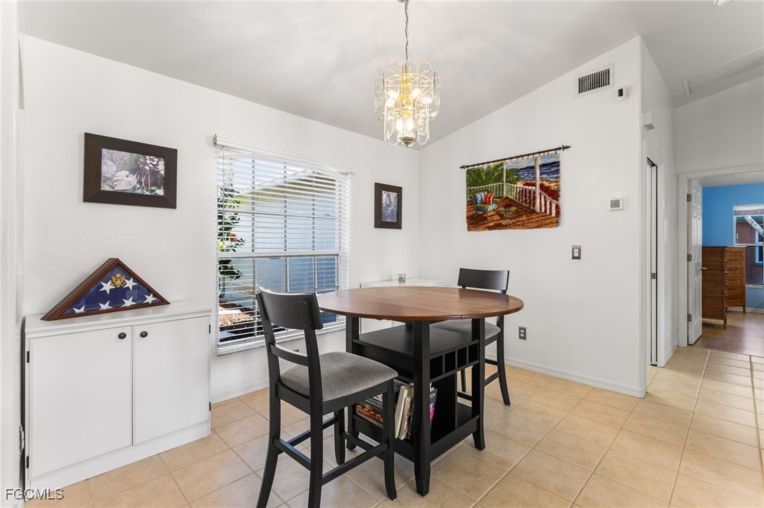2607 8th Street West Lehigh Acres, FL 33971 - Photo 11 of 48 a view of a dining room with furniture and chandelier