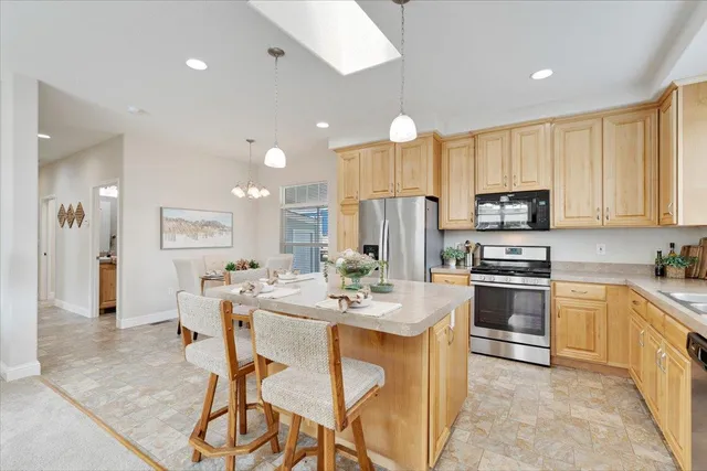 a large kitchen with kitchen island a dining table and chairs
