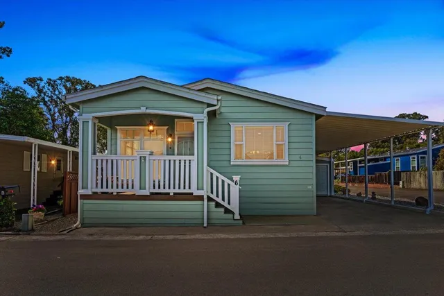 a view of a house with a small yard and potted plants