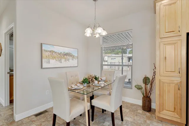 a dining room with furniture a chandelier and window