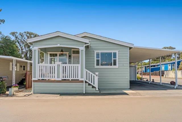 a view of a house with a small yard and wooden fence