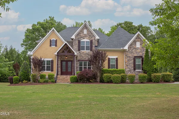 a front view of a house with a garden