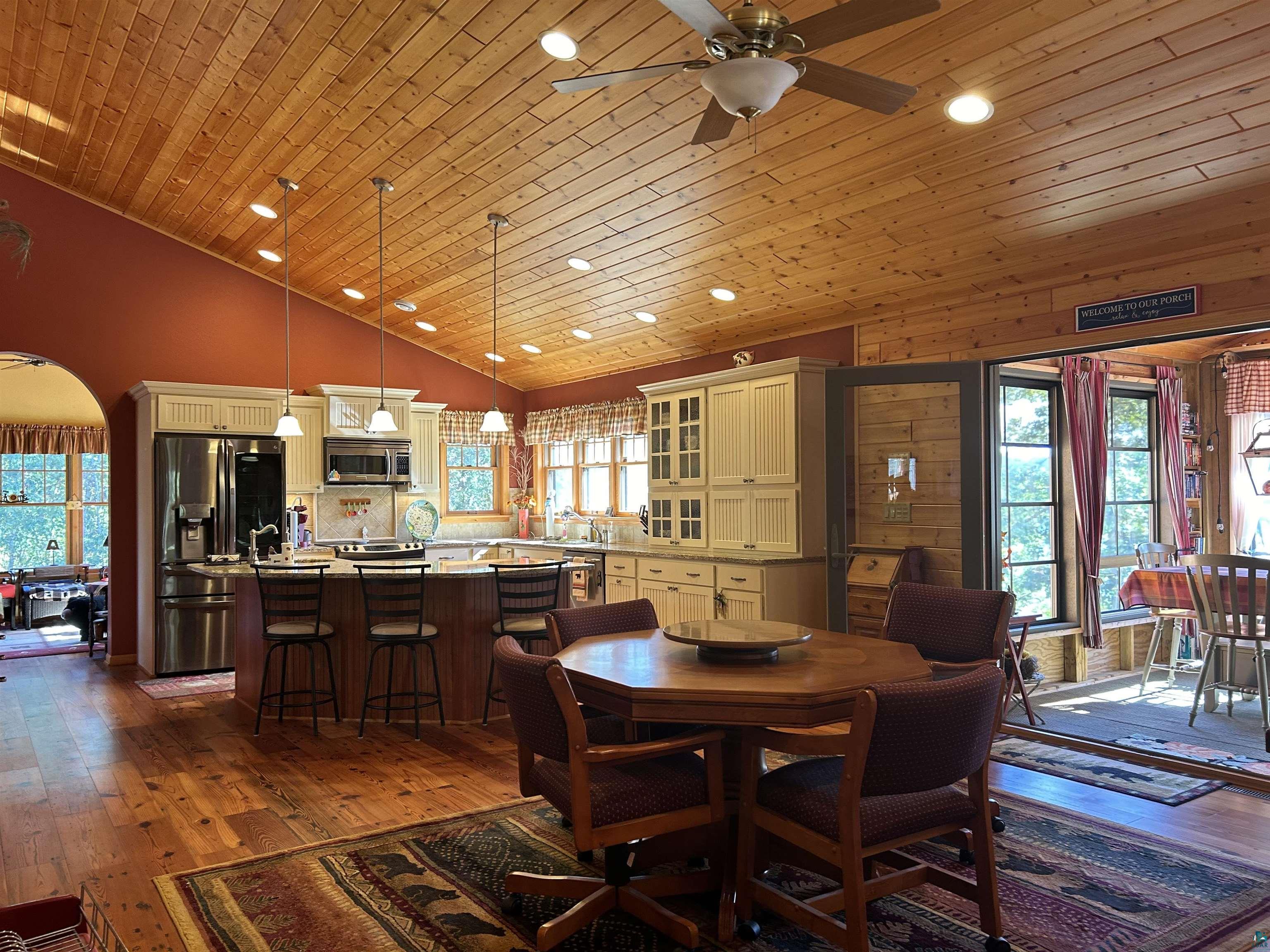 10115 Island Lake Road Solon Springs, WI 54873 - Photo 19 of 56 Dining room with a ceiling fan, arched walkways, recessed lighting, dark wood-style floors, and healthy amount of natural light