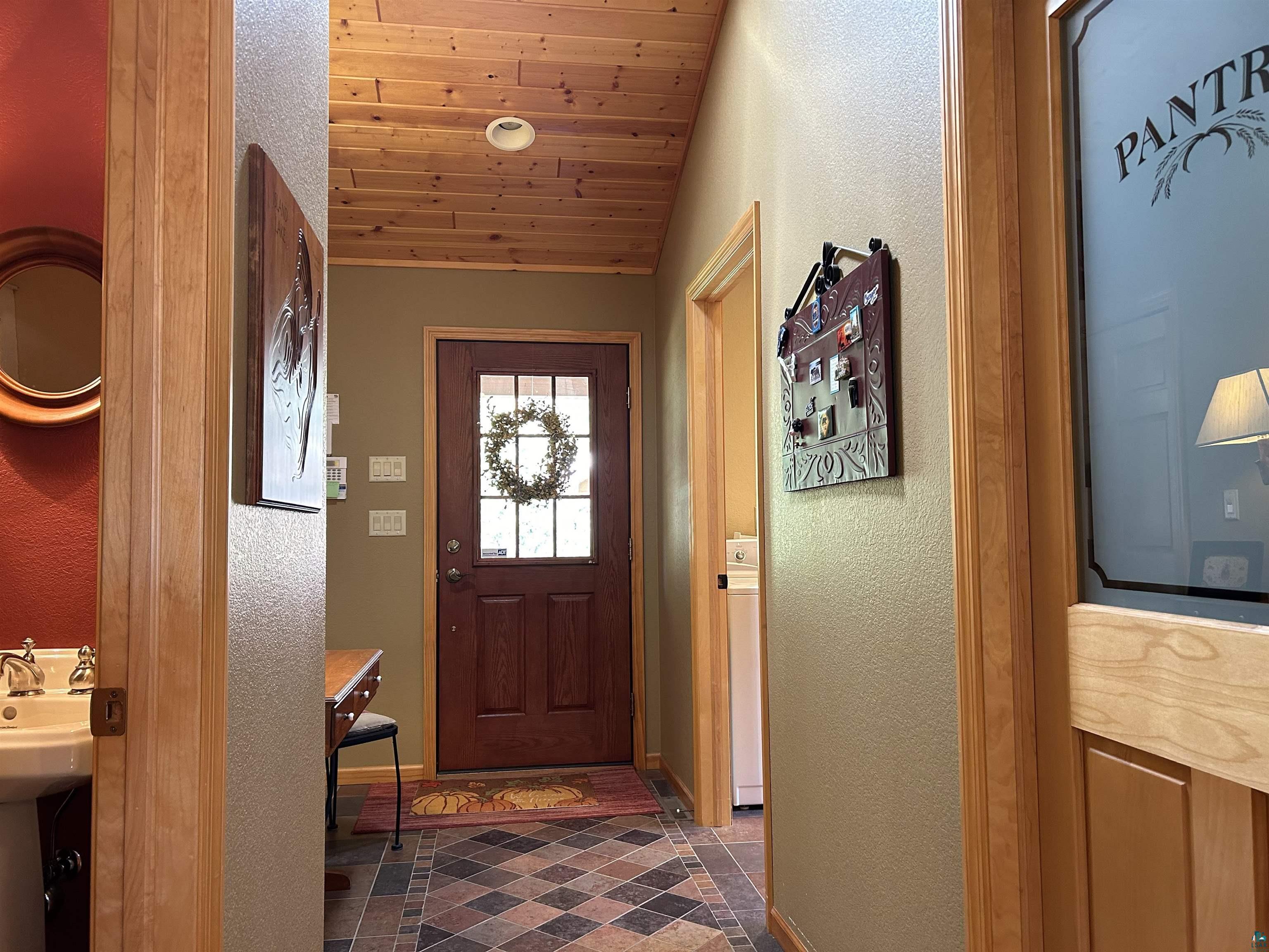 10115 Island Lake Road Solon Springs, WI 54873 - Photo 25 of 56 Doorway with vaulted ceiling, baseboards, a textured wall, and wood ceiling
