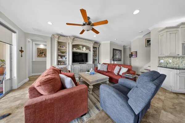 a living room with furniture a flat screen tv and a large window