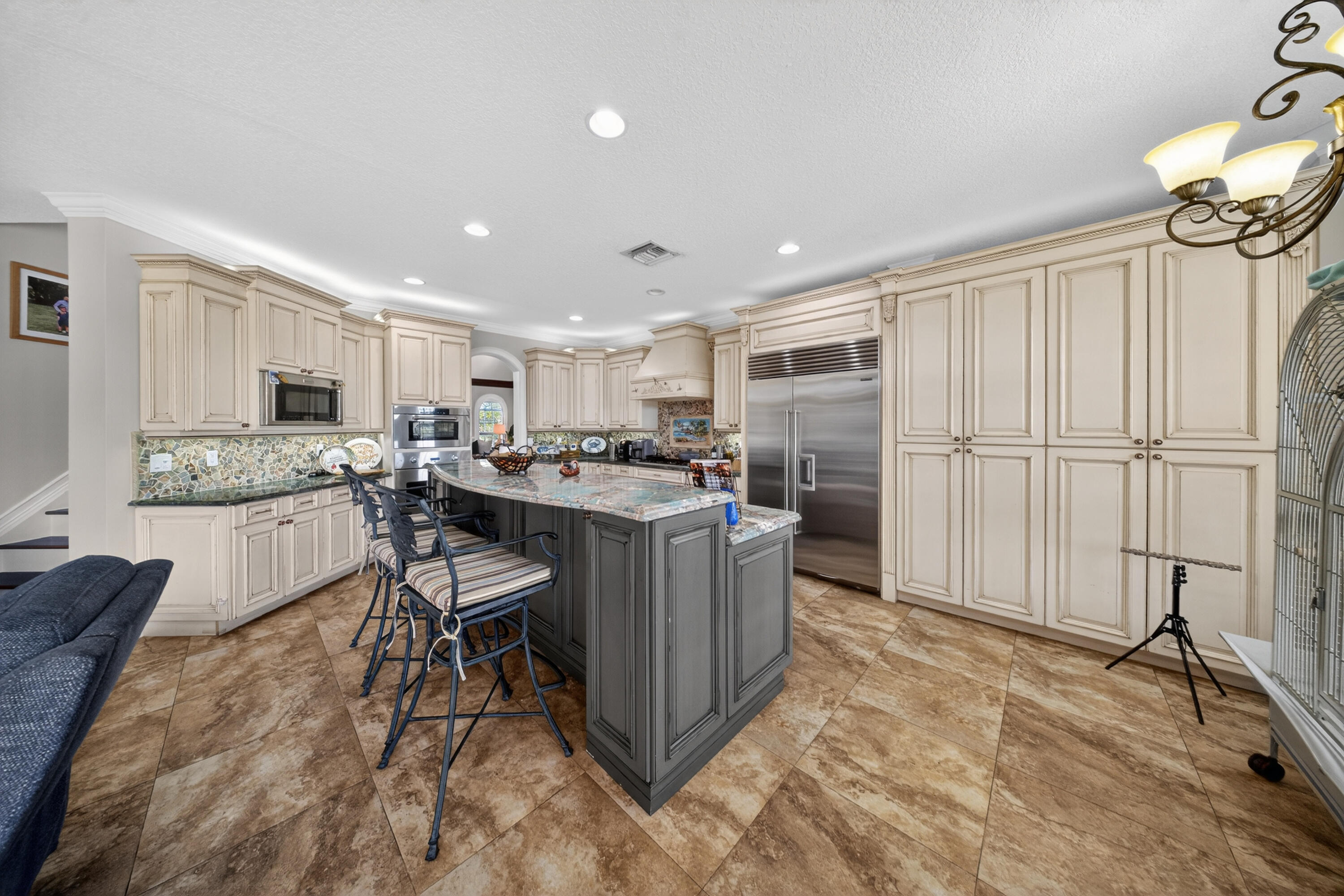 1315 Southeast Conference Circle Stuart, FL 34997 - Photo 14 of 55 a room with stainless steel appliances kitchen island granite countertop a table chairs sink and cabinets