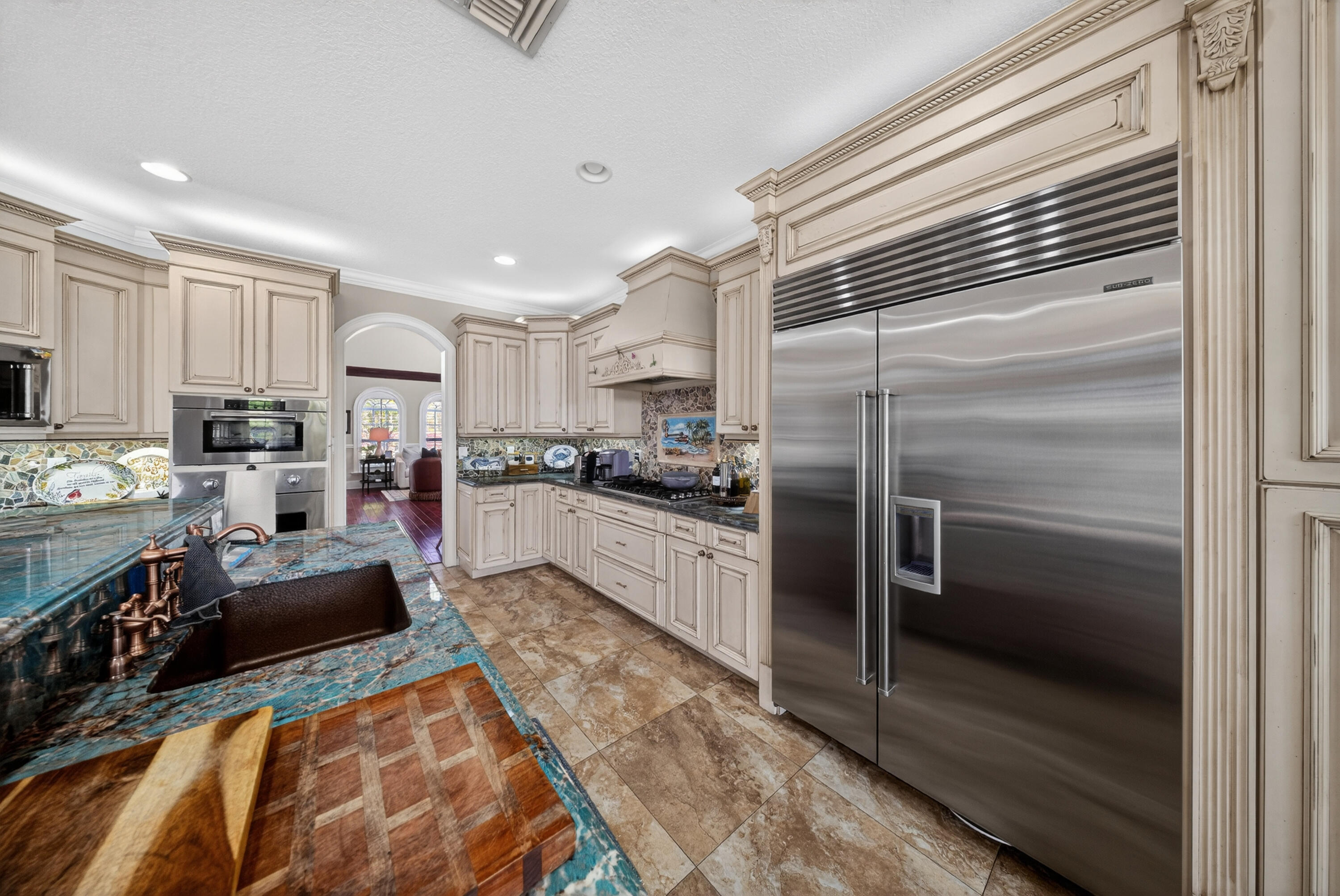 1315 Southeast Conference Circle Stuart, FL 34997 - Photo 15 of 55 a kitchen with stainless steel appliances kitchen island granite countertop a refrigerator a stove and a sink with wooden floor