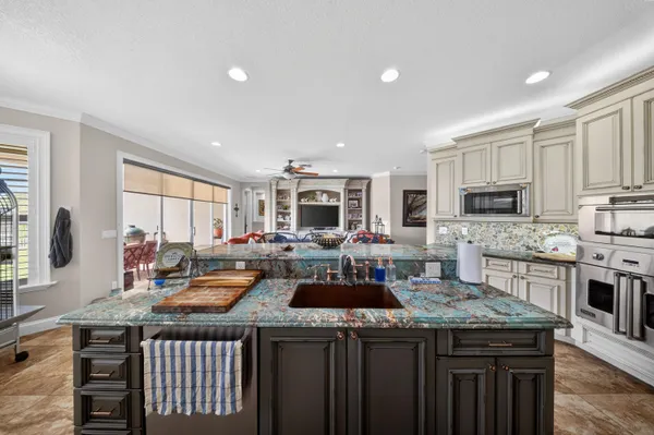 a kitchen with stainless steel appliances granite countertop a stove a sink and a microwave