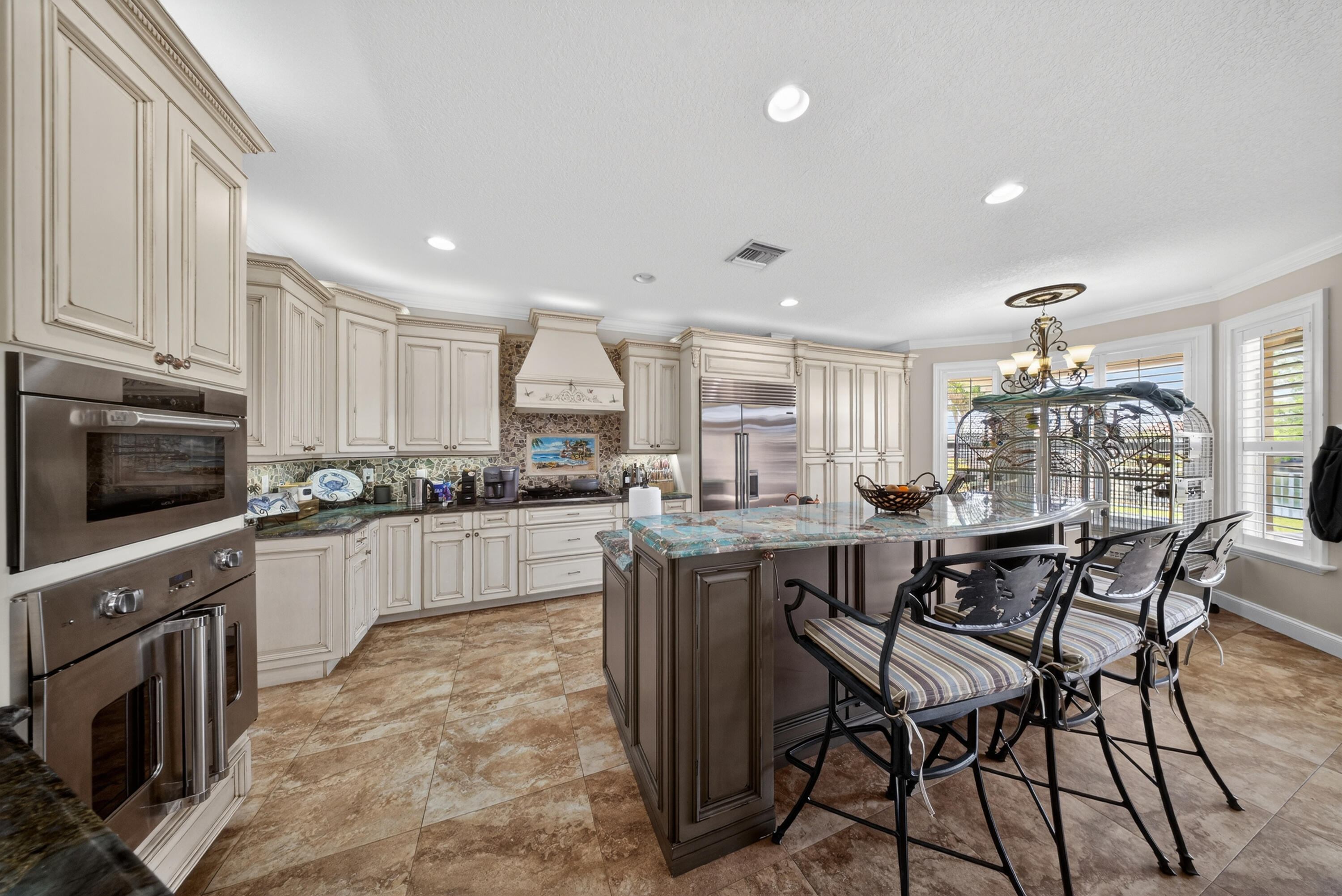 1315 Southeast Conference Circle Stuart, FL 34997 - Photo 20 of 55 a kitchen with stainless steel appliances kitchen island granite countertop a table chairs sink and cabinets