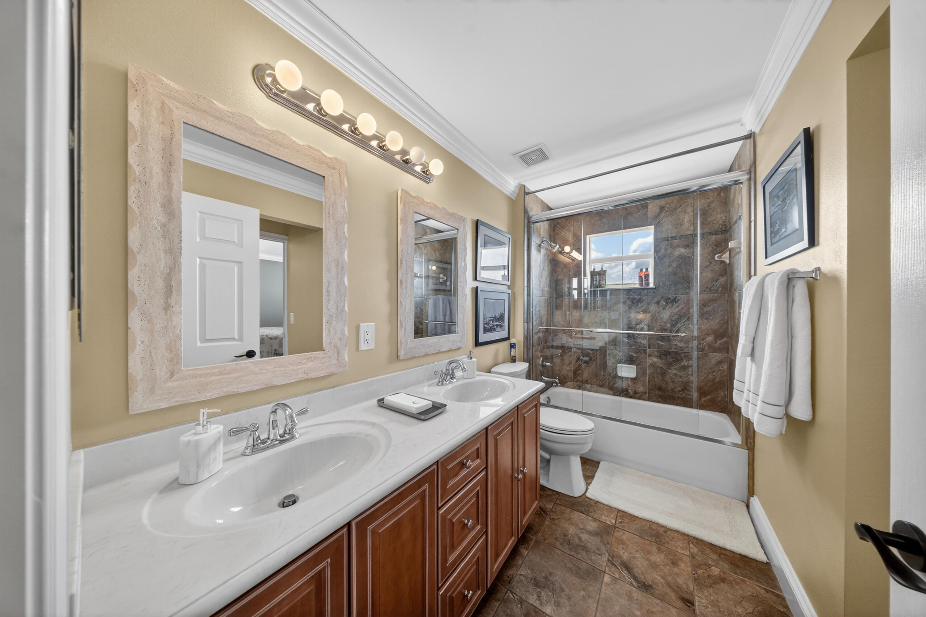 1315 Southeast Conference Circle Stuart, FL 34997 - Photo 39 of 55 a bathroom with a double vanity sink toilet mirror and shower