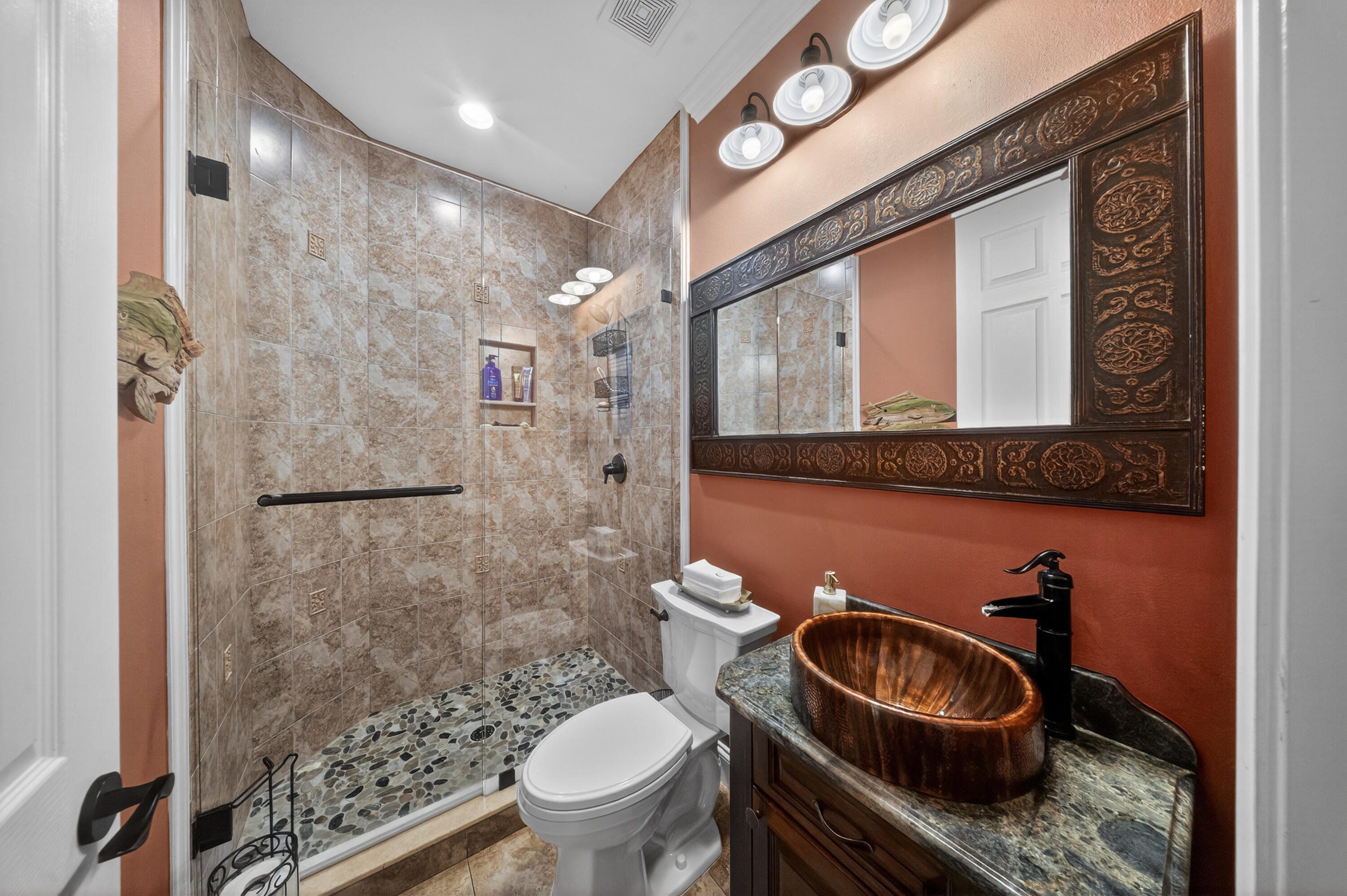 1315 Southeast Conference Circle Stuart, FL 34997 - Photo 9 of 55 a bathroom with a granite countertop toilet sink and mirror