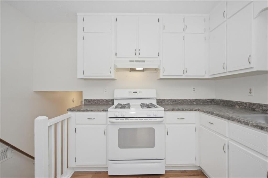 1496 Cherry Hill Road Southwest Conyers, GA 30094 - Photo 6 of 32 a kitchen with granite countertop white cabinets and white appliances
