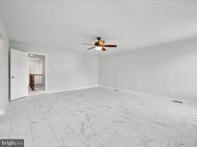 a view of a room with a ceiling fan and window