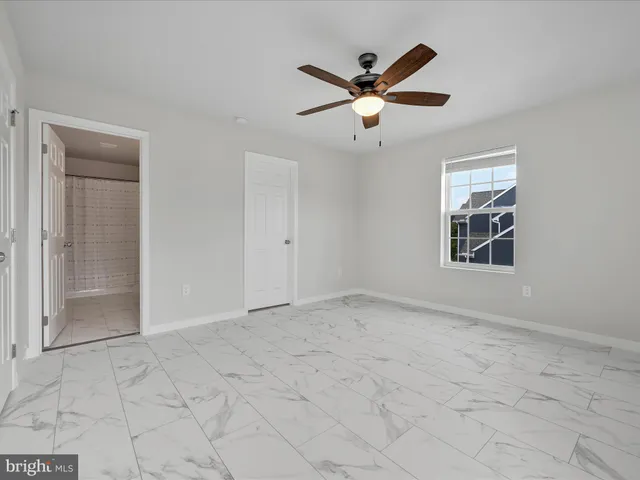an empty room with closet and windows