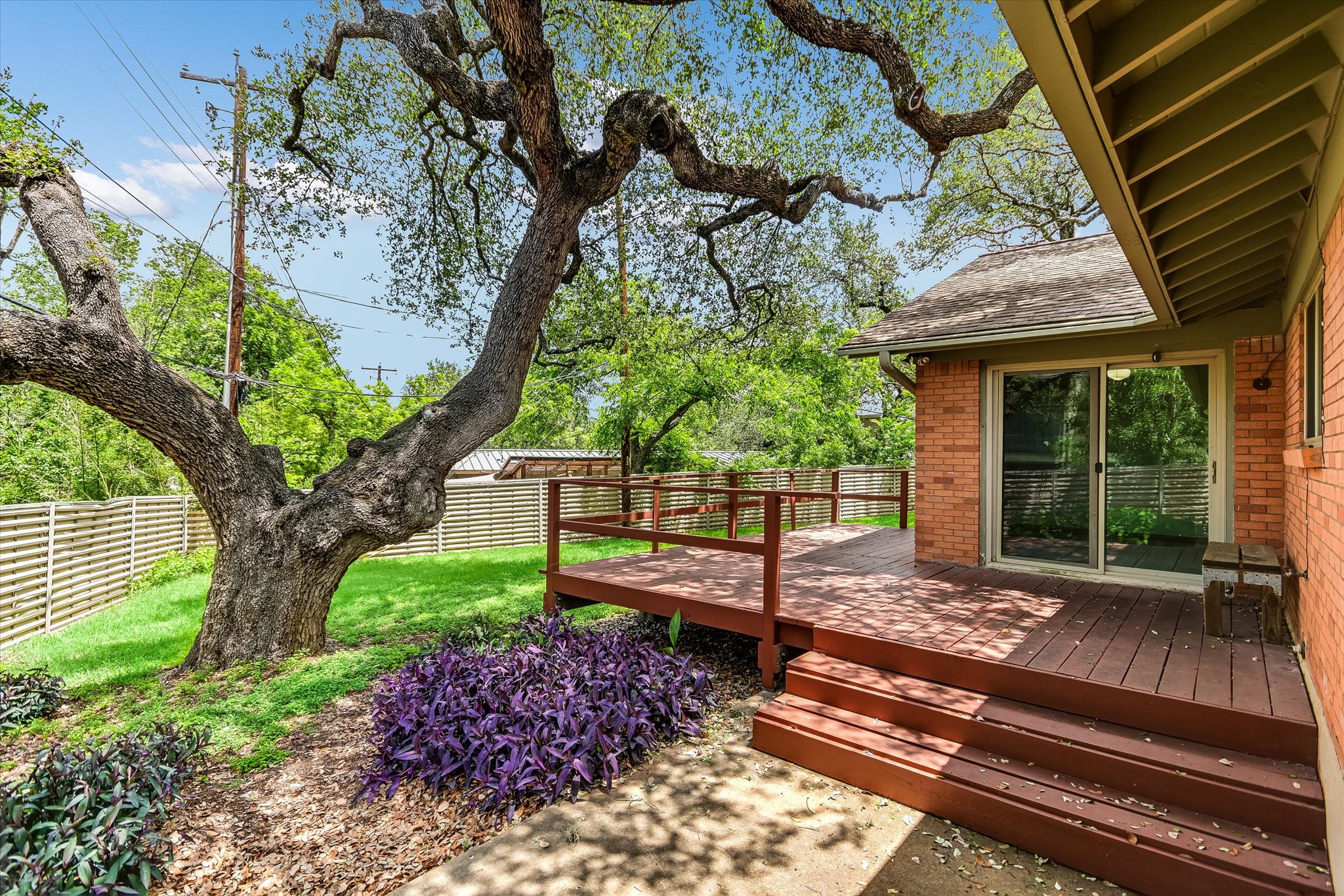 502 Sunset Circle Austin, TX 78704 - Photo 18 of 27 Expansive backyard featuring a wood deck with railing, a sliding glass door entry to the house