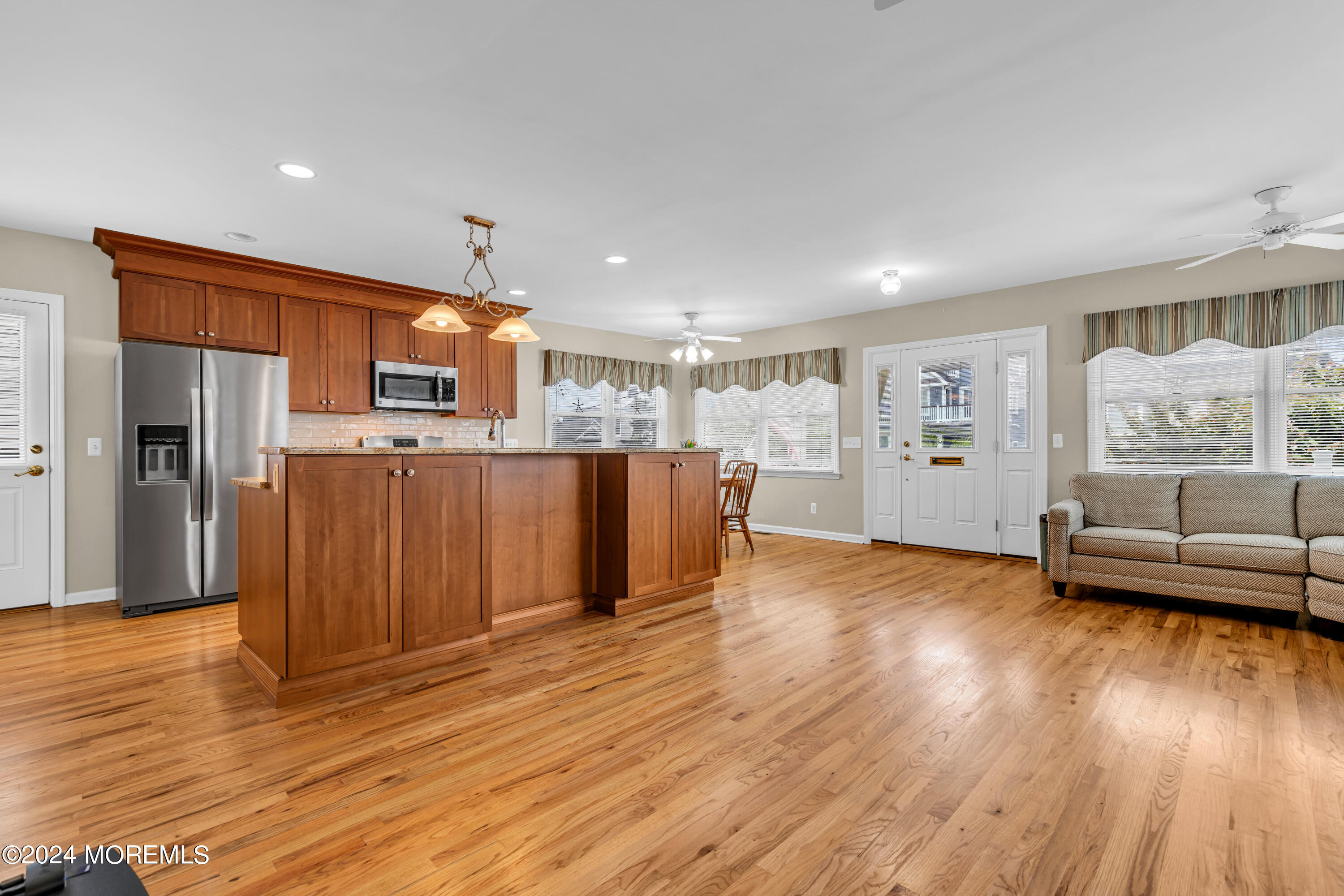 564 Perch Avenue Manasquan, NJ 08736 - Photo 4 of 49 a view of a living room a kitchen with furniture and wooden floor