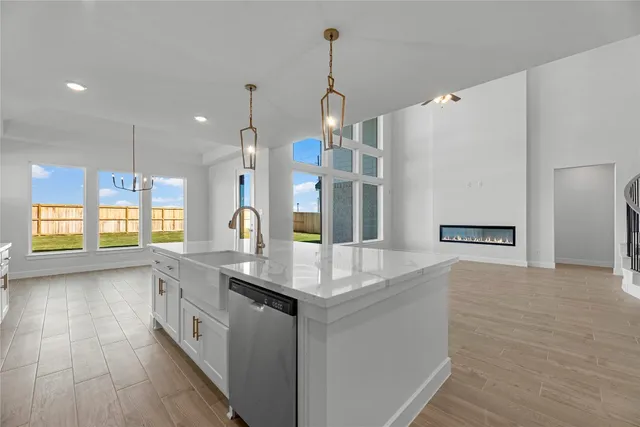 a large white kitchen with granite countertop a stove and a sink