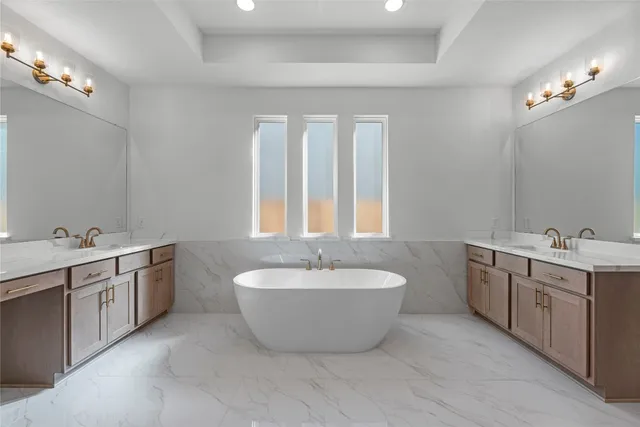a spacious bathroom with a double vanity sink mirror and bathtub