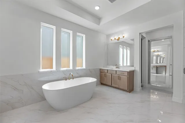 a spacious bathroom with a double vanity sink a mirror and a bathtub