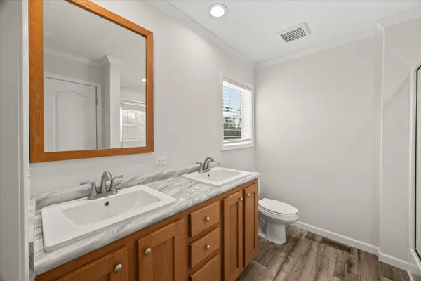 a bathroom with a granite countertop sink a toilet and a mirror