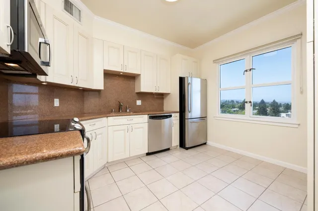 a kitchen with a sink a refrigerator and cabinets