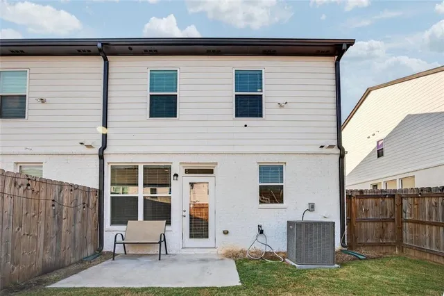 a backyard of a house with lawn chairs and wooden fence