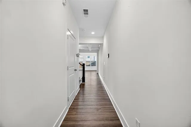 a view of a hallway with wooden floor and staircase
