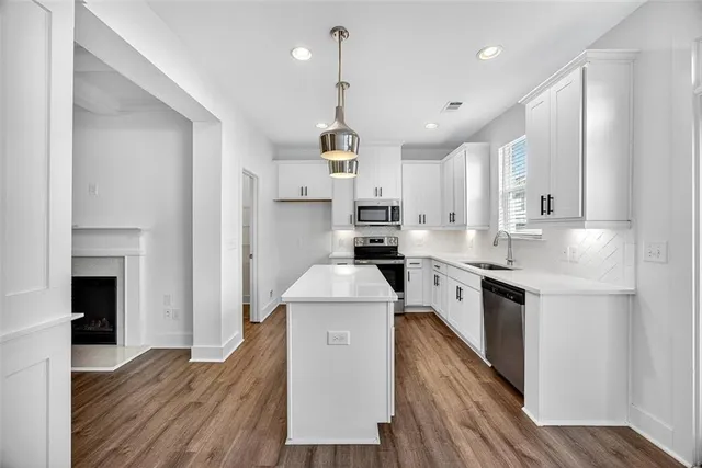 a kitchen with white cabinets stove and refrigerator