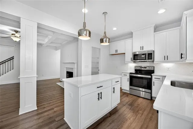 a kitchen with stainless steel appliances kitchen island granite countertop a stove a sink and a refrigerator