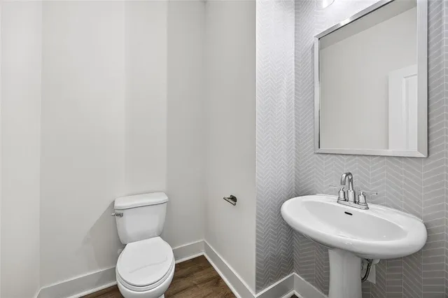 a bathroom with a sink a toilet and mirror