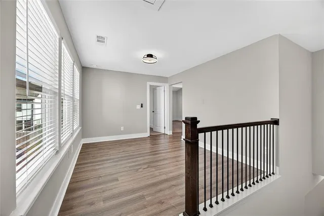 a view of a hallway with wooden floor and windows