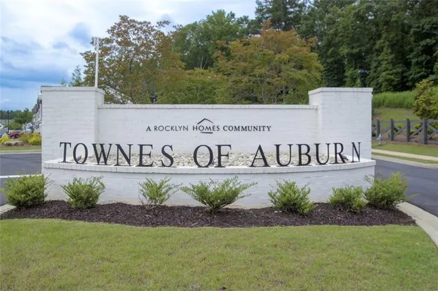 a sign of golf club on a wall under a tree