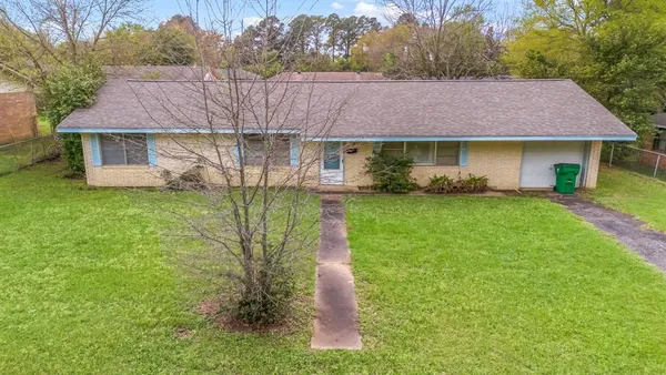 a aerial view of a house next to a big yard and large tree